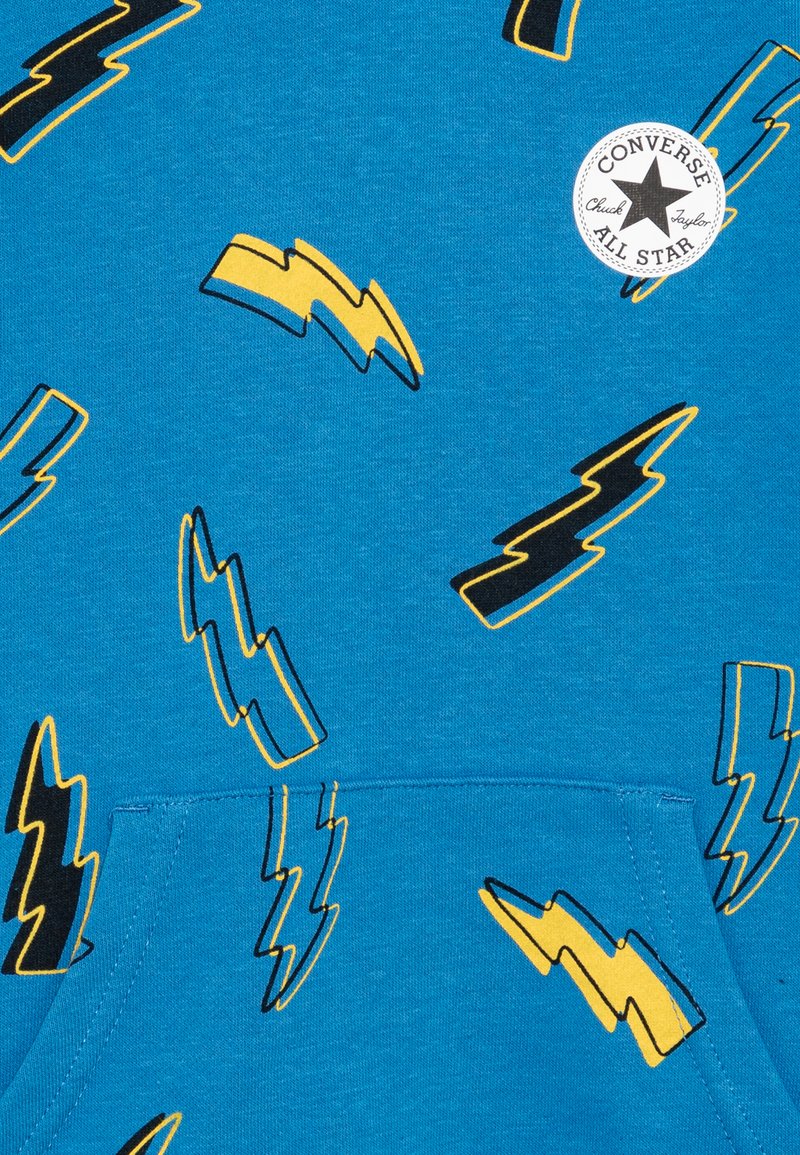 Modrá bavlněná mikina s kapucí, zdobená vzorem černých a žlutých blesků. Obsahuje přední kapsu a kulatou nášivku s logem.