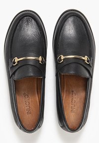 Černé kožené mokasíny se zlatými akcenty, zaoblenou špičkou a strukturovaným povrchem. Uvnitř se nachází hladká hnědá vnitřní stélka.