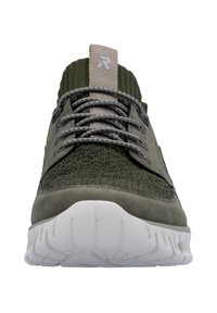 Baskets de sport vert foncé avec un dessus texturé, lacets gris et une semelle en caoutchouc blanche à rainures. Le col en tricot ajoute de la flexibilité.