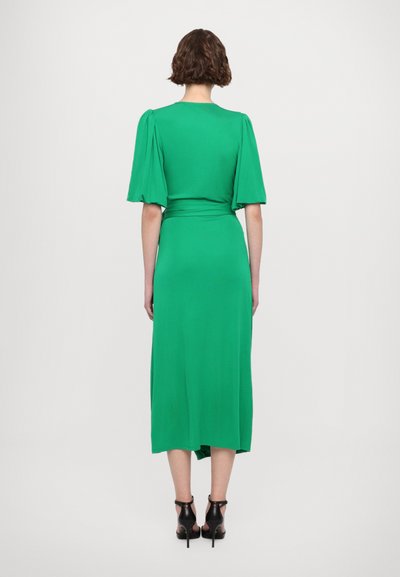 Green midi dress with puff sleeves, made from a smooth fabric. Features a cinched waist and a slightly flared hemline. Worn with black heels.