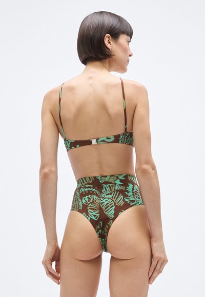 Barna bikini szett zöld grafikával ellátott szöveggel. Állítható pántok, magas derekú alsó rész, fémes kapocs a hátoldalon. Simább textúra.