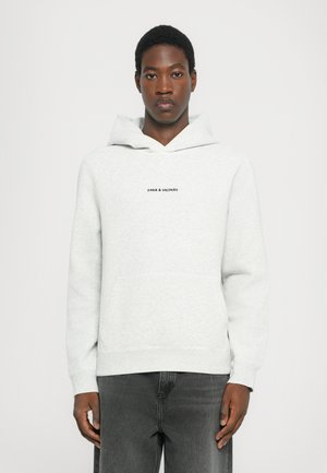 Light grey hoodie made of soft fabric, featuring a kangaroo pocket and drawstring hood. The front displays "Zadig & Voltaire" in black.