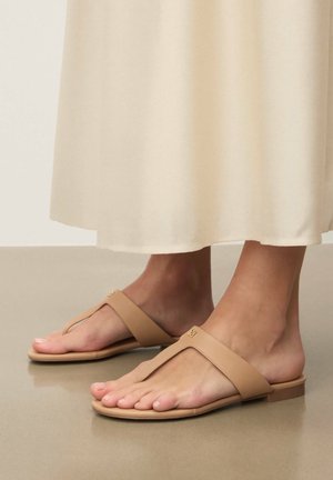 Béžové žabky s plochou podrážkou, s širokým remienkom a minimálnym logom. Hladká textúra, vhodné na bežné nosenie.