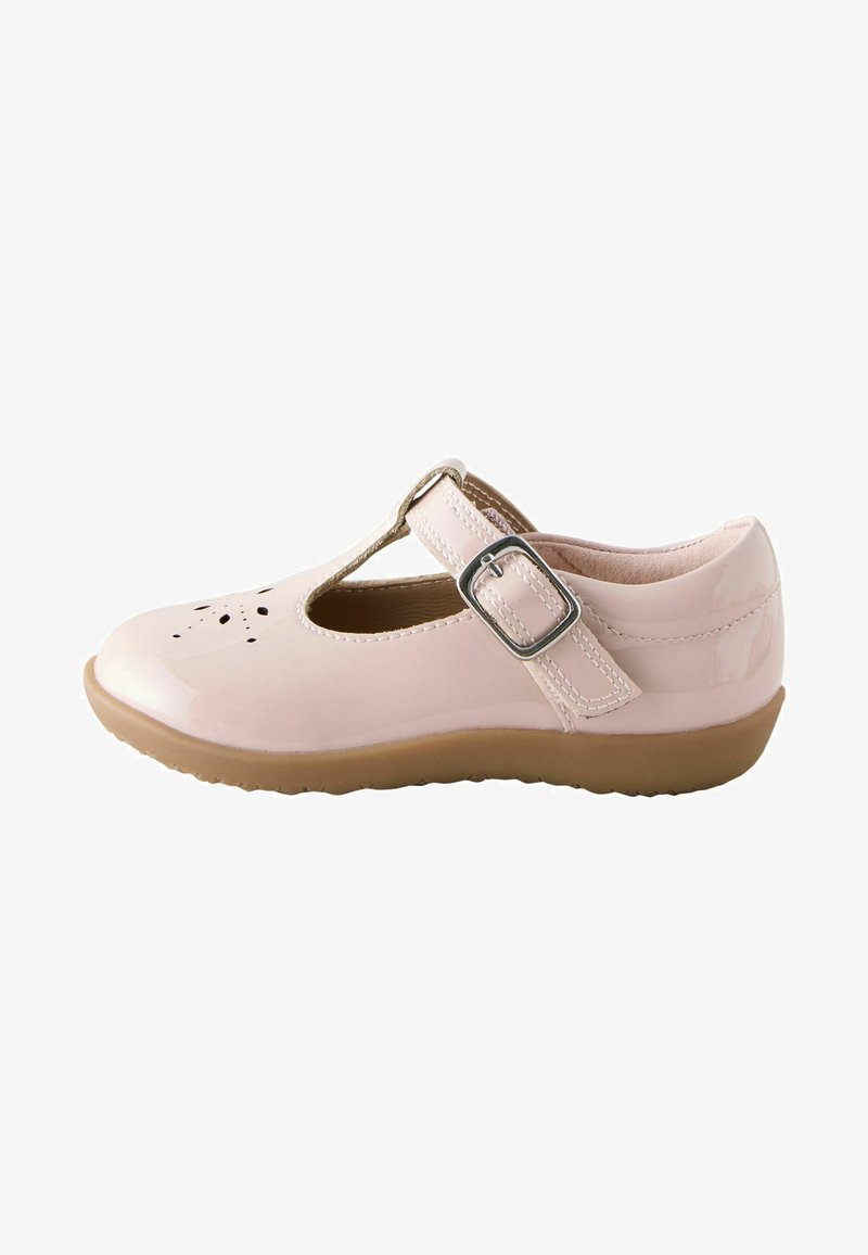 Chaussure Mary Jane en cuir verni rose clair avec motif perforé à l’avant, bride réglable avec boucle et semelle en caoutchouc marron.