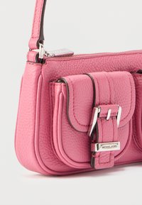 Ροζ δερμάτινη τσάντα χειρός με υφή στην επιφάνεια, που διαθέτει μπροστινό καπάκι και ασημένιες μεταλλικές λεπτομέρειες. Συμπαγές σχέδιο με ιμάντα ώμου.