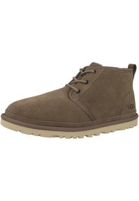 Stivaletti in suede marrone con punta tonda, design con lacci, suola beige a contrasto e branding discreto sul lato.