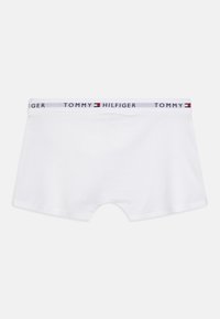 Fehér pamut boxeralsó, kontrasztos derékkal, rajta a "TOMMY HILFIGER" logóval és piros és kék téglalap alakú logó díszítéssel.