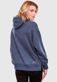 Felpa con cappuccio blu in misto cotone, con orlo a spacco laterale, polsini a costine e una piccola patch con logo in basso a sinistra.