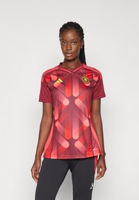 Raudonas gradientinis trumpas rankovėmis futbolo marškinėlis su geometriniais raštais, V formos apykakle ir Adidas logotipu su apvaliu emblemą ant krūtinės.