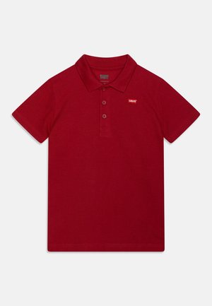 Rød polo med korte ærmer, krave og tre knapper, med en lille Levi's-logo på venstre bryst.