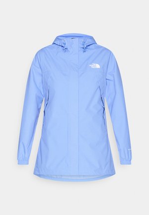 Lyseblå vandtæt jakke med hætte, elastiske manchetter og to sidelommer. Har logo på øverste venstre bryst. Glat tekstur.