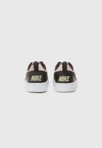 Črne in roza športne copate z belimi podplati, ki imajo zgornji del iz teksturirane usnje, vezalke in izrazito "Nike" blagovno znamko na peti.