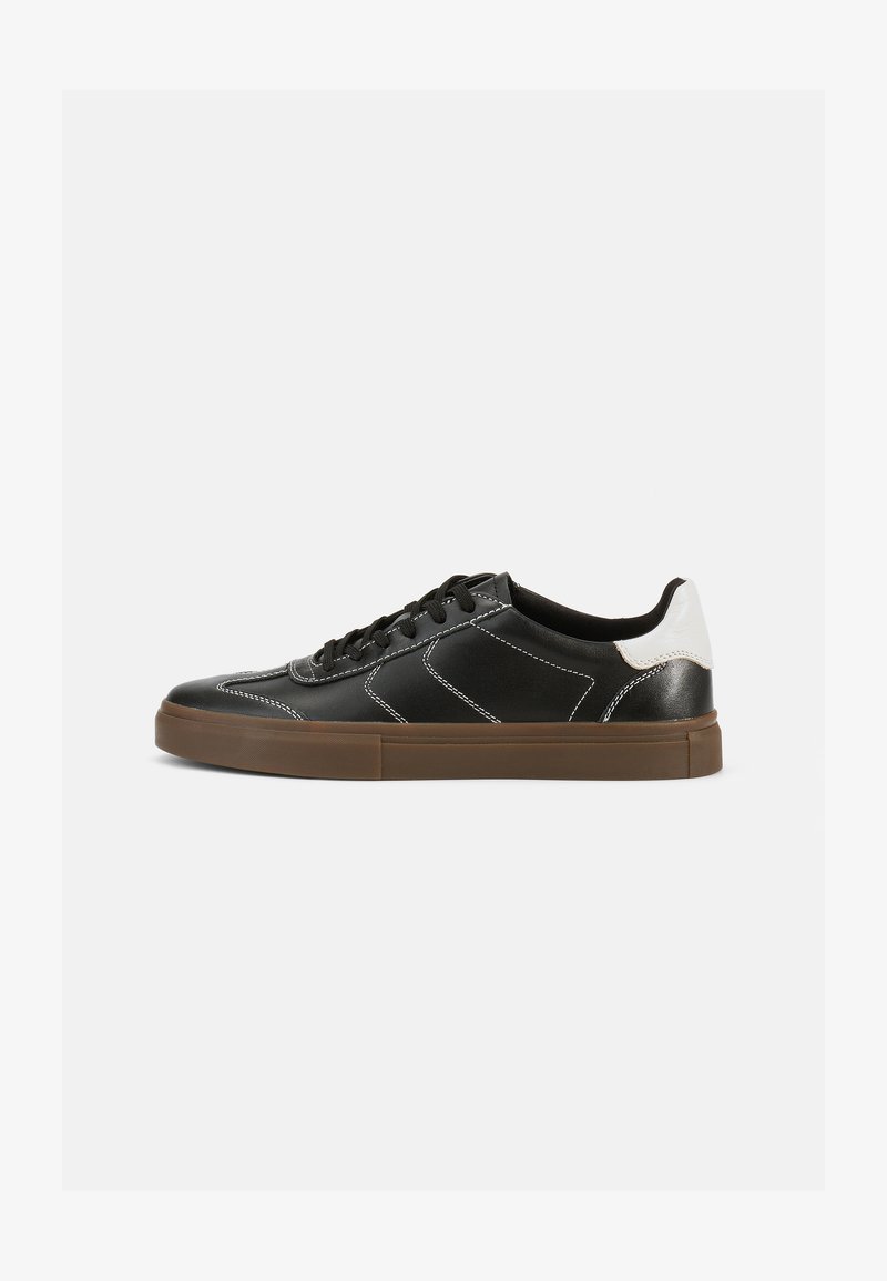 Czarne skórzane sneakersy z białymi szwami, wyróżniające się kontrastującym białym akcentem na pięcie, gumową brązową podeszwą oraz klasycznym sznurowanym wzorem.