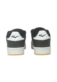 Sneakers bianco e nero con colletto imbottito, texture in pelle liscia e design a basso profilo. Dotati di suola in gomma e di un logo sul tallone.