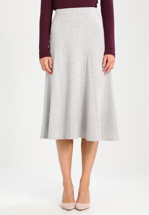 Een lichtgrijze, knie-lange, uitlopende rok van zachte stof, met subtiele plooien en een gladde textuur, gecombineerd met naakte hakken.