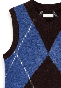 Chaleco sin mangas en marrón oscuro y azul con patrón de argyle. Textura suave, cuello acanalado y detalle de costura blanca entre los rombos.