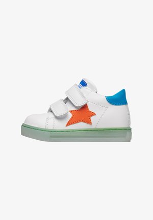 Hvid børnesneaker med grøn sål, orange stjerne på siden, blå hælplade og to hvide velcroremme.