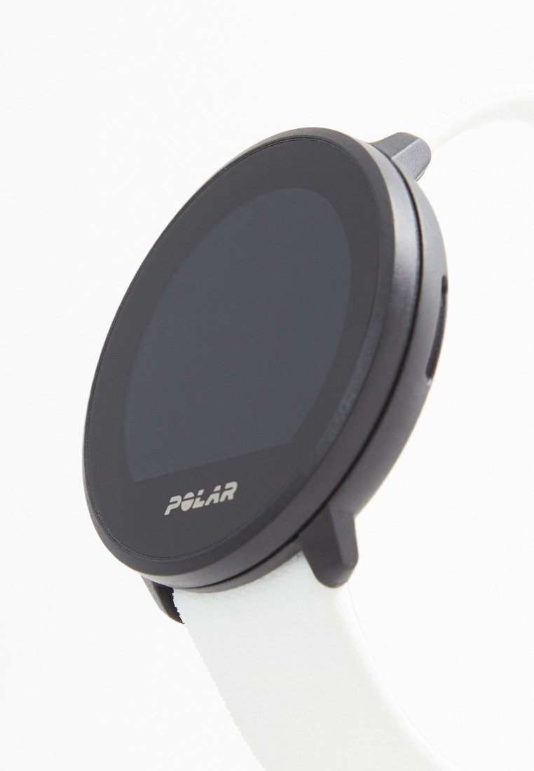 Reloj Polar con una esfera redonda negra, correa de silicona blanca y un diseño minimalista. Presenta un logotipo prominente en la esfera y un botón lateral.