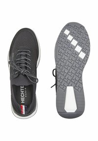 Schwarze Mesh-Sportschuhe mit strukturiertem Obermaterial, Schnürverschluss und weißen Akzenten; ausgestattet mit einer gemusterten Gummisohle mit Grip-Zonen.