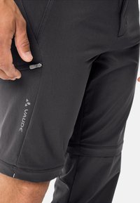 Zwarte shorts van lichtgewicht stof. Bevat een ritszak en een logo op de linker dij. Het ontwerp is stijlvol en functioneel.