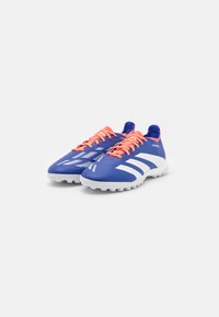 Modré sportovní boty s bílými akcenty, strukturovaný svršek a oranžové tkaničky. Jsou vyrobeny s elegantním designem a moderním vzorem na boku.