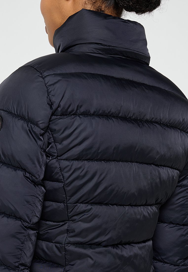 Giacca imbottita blu navy con colletto alto, caratterizzata da sezioni trapuntate orizzontali e una texture liscia. Include un logo sulla spalla.