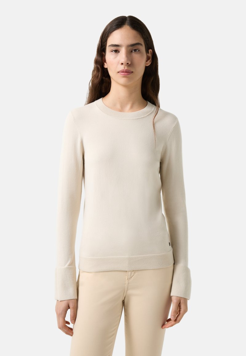 Heller beiger Langarmpullover mit rundem Halsausschnitt und gerippten Bündchen, aus weichem Material gefertigt. Verfügt über eine dezente Textur und eine figurbetonte Silhouette.