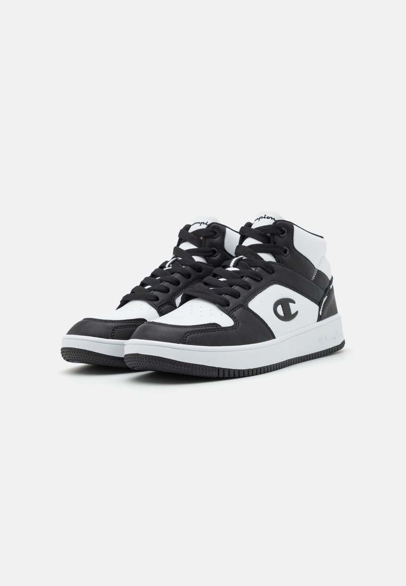 Schwarze und weiße Sneakers mit einem Design aus Leder und Mesh, ausgestattet mit einer runden Zehenpartie, Schnürung vorne und einem Logo an der Seite. Gummisohle.