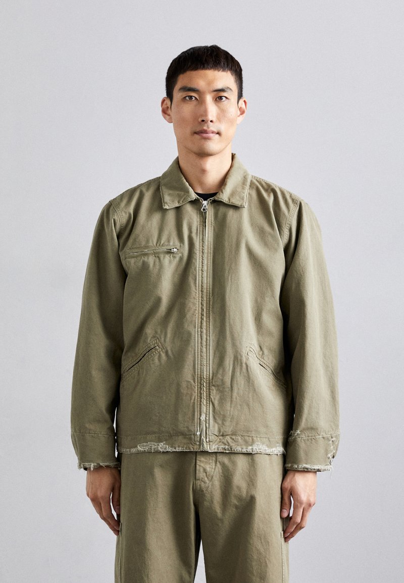Olive green, zip-up jacket in lightweight material. Features a collared neck, front pockets, and unfinished hem details.