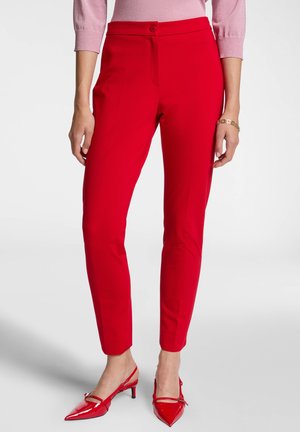 Pantaloni rossi su misura con fronte piatto, chiusura con bottone e gambe affusolate, realizzati in tessuto morbido con un design elegante.