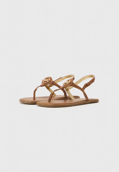 Bruna lädersandaler med guldhardwaredetaljer, med en tångdesign och justerbar vristrem, försedda med en platt sula och sömnadsdetaljer.
