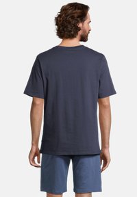 Marineblauw T-shirt met korte mouwen van katoen, met een ronde hals en een relaxte fit, gecombineerd met lichtblauwe shorts.