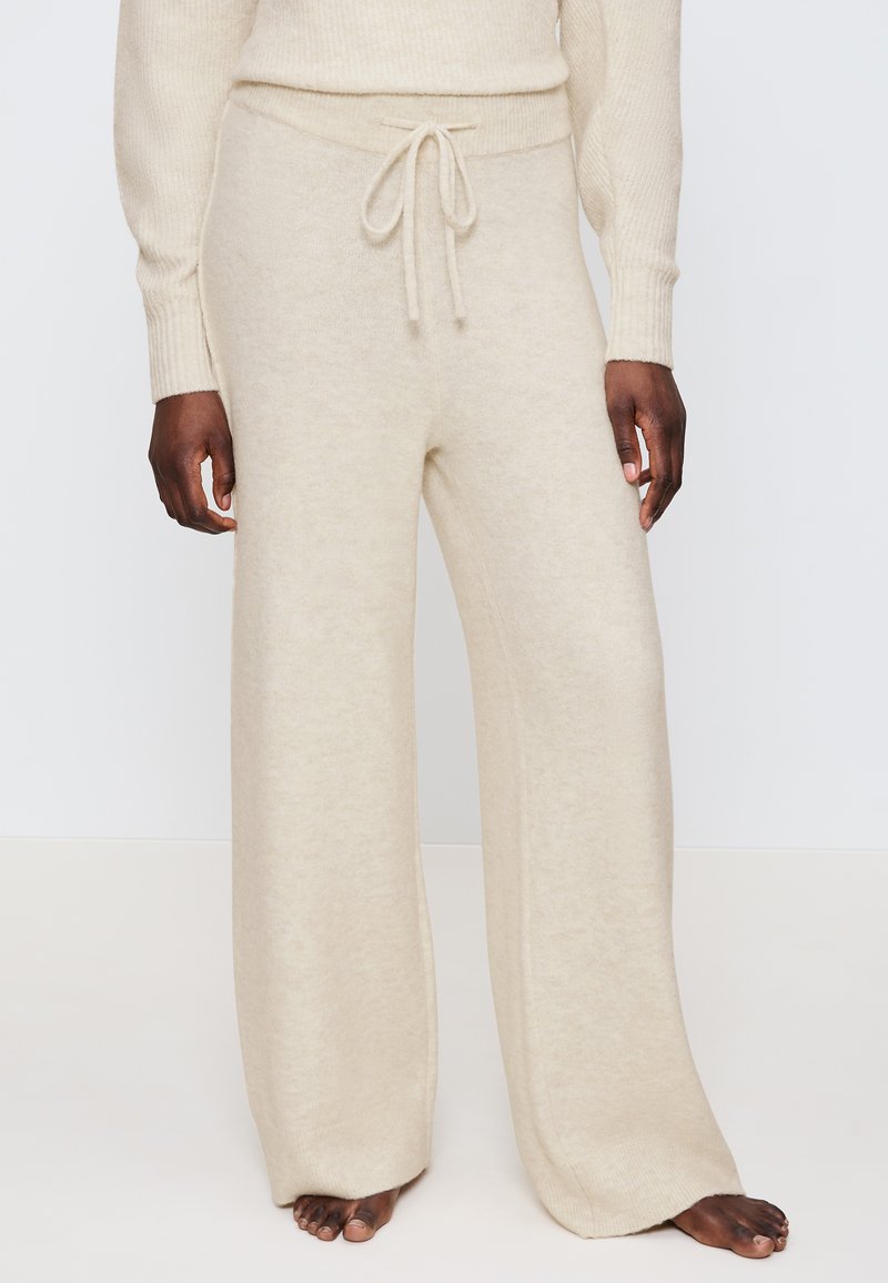 Beige Weite-Hosen aus weichem, strukturiertem Stoff, mit einem Kordelzug am Bund und Rippenakzenten am Bund und Saum.