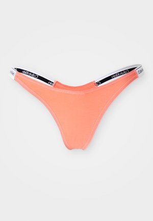 Lys korall thong-truser laget av en myk bomullsmiks, med et svart og hvitt Calvin Klein-logo belte og et minimalistisk design.