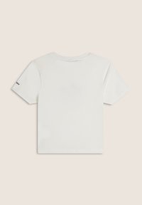 Camiseta blanca de algodón con mangas cortas, cuello redondo y un pequeño logo negro en la manga izquierda. Textura suave, corte recto.