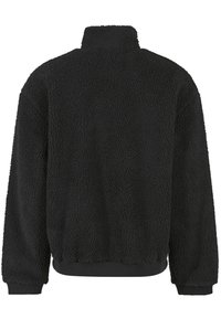 Zwarte fleecejas met een hoge kraag, lange mouwen en geribbelde boorden bij de mouwen en zoom, van achteren weergegeven tegen een witte achtergrond.