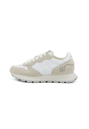 Sneaker in pelle scamosciata bianca e beige con chiusura stringata, suola beige e perforazioni decorative vicino al tallone su sfondo bianco.