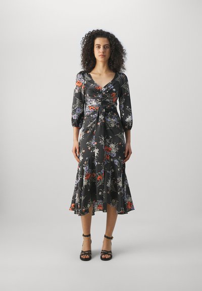 Schwarzes Blumenkleid mit dreiviertel Puffärmeln, tailliertem Bund und rüschengesäumtem Saum. Das Kleid verfügt über bunte Blumenmuster und einen weichen, glatten Stoff.
