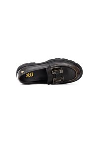 Zapato negro tipo slip-on con puntera redondeada, material de cuero liso, detalles de hardware dorado y suela texturizada. Presenta un detalle de doble hebilla.