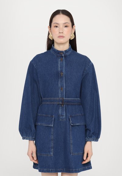 Denim dress with a high collar, long puff sleeves, front button closure, waist belt, and two patch pockets in dark blue fabric.