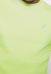 Kortärmad t-shirt med rund hals i ljus limegrön bomullsblandning. Har en diskret broderad Nike-logotyp på bröstet. Mjuk textur.