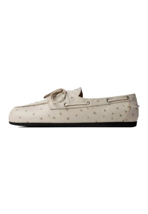 White loafer shoe with textured dotted pattern, lace detail around the heel, and black flat sole, shown from the side on a white background.