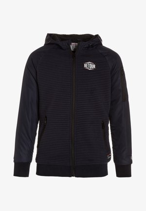 Granatowa kurtka z kapturem o prążkowanej fakturze, z zamkiem błyskawicznym z przodu, kieszeniami na zamek oraz logo „RETOUR” na piersi.