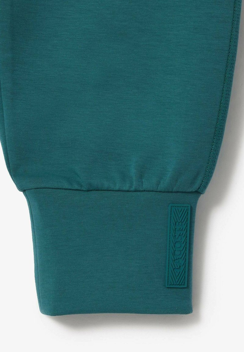 Niebieska bluza z mankietami o ribbowym wzorze i wypukłym znakiem logo. Gładki materiał z dopasowanym krojem, charakteryzująca się prostym, czystym wykończeniem.