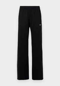 Pantaloni sportivi negri cu un design cu picior larg, talie elastică, buzunare laterale și dungi albe contrastante pe laterale; logo-ul Nike în partea stângă sus.