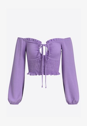 Top court violet, épaule dénudée, manches longues, devant froncé, lien à nouer et accents à volants le long de l'encolure et de l'ourlet.
