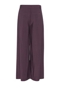 Housut leveällä lahkeella tumman violetin värisinä, joissa on sileä pinta, korkea vyötärö vetoketjulla ja kaksi takataskua.
