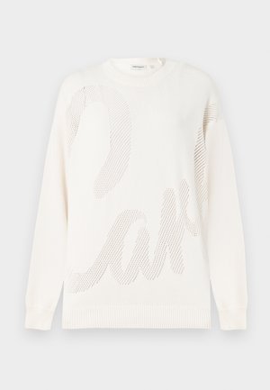 Witte gebreide trui met een groot gaaspatroon dat lijkt op het woord "cake." Ribbelboord bij de hals en mouwen; zachte textuur.