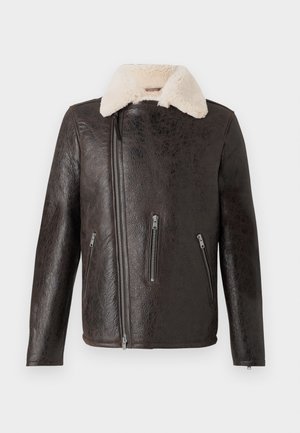 Veste en cuir marron avec un col en shearling blanc, dotée d'une fermeture éclair à l'avant et de deux poches zippées de chaque côté. Finition texturée.