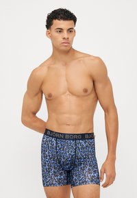 Modri leopardji potisk boxer šortiji z črnim pasom, na katerem je napis blagovne znamke "BJÖRN BORG." Narejeni iz mehkega, raztegljivega materiala.